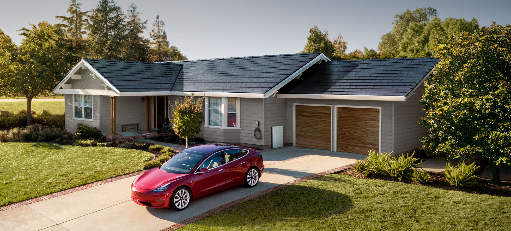 Casa amb les teules Tesla instal·lades, bateria i cotxe